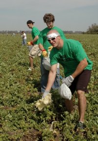 UND hockey players (front to back) Kyle Radke, Taylor Chorney and Joe Finley help clear a field of debris. 