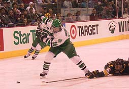 North Dakota's Tim Skarperud winds up for a shot while CC's Colin Stuart tries to break up the play.  Photo by Jason Waldowski.