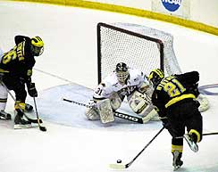 Michigan's Erik Nystrom comes in on DU goalie Wade Dubielewicz in the Pioneers' season-ending loss on Saturday. (photo by Christopher Brian Dudek)