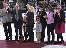 Bob Olson (second from left) acknowledges the crowd during a pre-game ceremony in his honor. Standing with him are MTU coach Mike Sertich, daughters Ramona, Kristina, Julie and Perian, and two granddaughters.