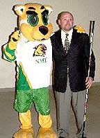 New NMU coach Walt Kyle poses at the news conference with the team mascot.