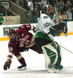 North Dakota goalie Jake Brandt plays the puck out of reach of Denver's onrushing Conner James.  (Photo: Patrick C. Miller)