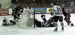 Players scramble around the net as Harvard's Dov Grumet-Morris tries to freeze the loose puck. The junior netminder made 30 saves as the Crimson swept Brown in the ECAC quarterfinals. (photo: Chris Gerlt)