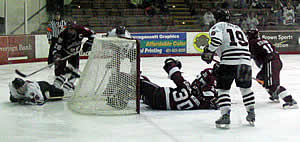 Players scramble around the net as Harvard's Dov Grumet-Morris tries to freeze the loose puck. The junior netminder made 30 saves as the Crimson swept Brown in the ECAC quarterfinals. (photo: Chris Gerlt)
