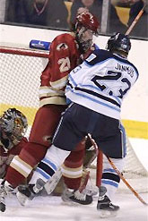 Ryan Caldwell fends off Maine's Jon Jankus in front of the Denver net. (photo: Pedro Cancel)