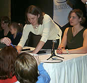 Chanda Gunn and Angela Ruggiero sign autographs for young fans.