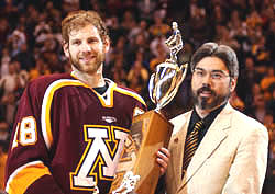 Grant Potulny holds the Broadmoor Trophy after the Gophers' title win (photos: Jason Waldowski).