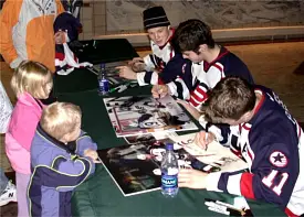 The trio signs autographs at UND's Ralph Engelstad Arena in Grand Forks.