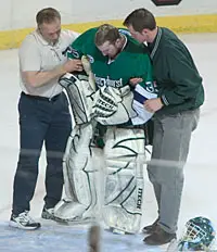 Goaltender Mike Ella is helped off the ice here, but returned to keep the Lakers in the hunt.