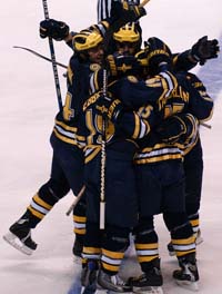 The Wolverines congratulate Jeff Tambellini after his first-period goal.
