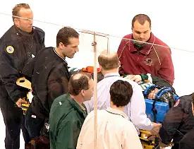 Emergency personnel take UND's Robbie Bina off the ice at the WCHA Final Five.