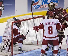 Robbie Earl (l.) climbs out of the net after tying the game at 1 in the second period.  Earl, who scored three goals in two games, was the Frozen Four Most Outstanding Player (photo: Melissa Wade).