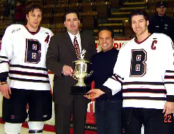 Assistant Captain Gerry Burke '05, Head Coach Roger Grillo, Providence Mayor David Cicilline (Brown Class of '83), and Captain Les Haggett '05 accepting the Mayor's Cup after last year's 5-1 Brown win (photo: Brown sports information).