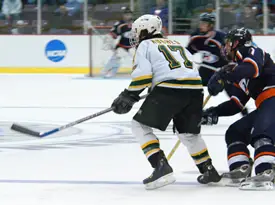 Connor Hughes chases the loose puck during overtime. Hughes tallied the winning goal for St. Norbert. (photo: Angelo Lisuzzo)