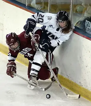UNH's Maggie Joyce (R) and Harvard's Jennifer Sifers battle for the puck in the first period. (Photo: Josh Gibney)