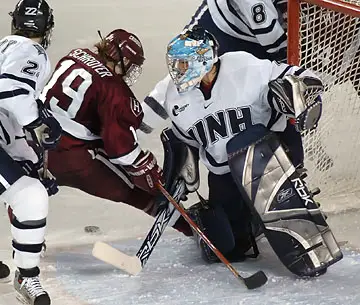 UNH goalie Melissa Bourdon stops Harvard captain Carrie Schroyer's search for a rebound. (Photo: Josh Gibney)