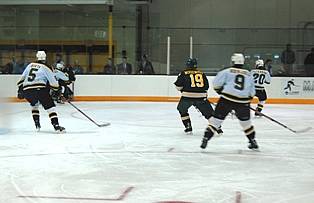 Oswego's Ryan Woodward (19) skates among four Green Knights. (photos: Scott Bridges)