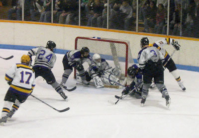 Stevens Point's Nick Zebro (22) tries to jam the puck past several St. Thomas defenders while Dan Francis (17) looks on. (photo: Matthew Webb)