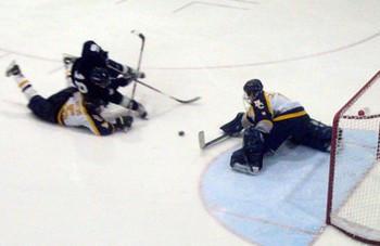 UW-Stout freshman forward Scott Motz gets hauled down on a breakaway against Neumann. (photo by Matthew Webb)