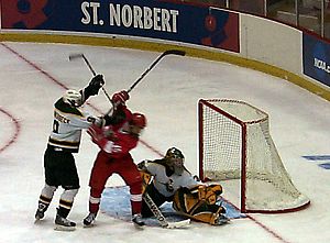 St. Norbert's Kyle Jones makes a save while players battle in front (photos: Russell Jaslow).
