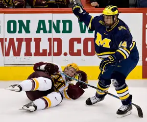 Minnesota's Ryan Stoa (l.) goes down to the ice Saturday alongside Michigan's Brian Lebler (photo: Melissa Wade).