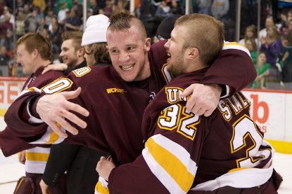 UMD co-captain Andrew Carroll and Alex Stalock -- both wearing the Bulldogs' playoff mohawks -- hug postgame (photo: Jim Rosvold).