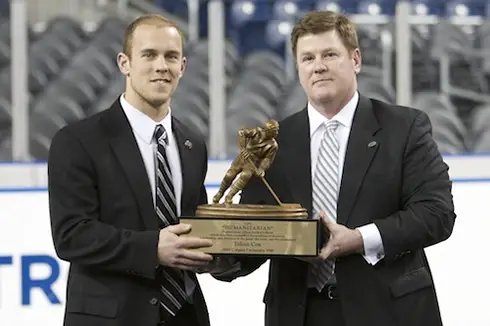 Colgate's Ethan Cox accepts the Hockey Humanitarian Award from Chuck Long at the Frozen Four in Detroit (photo: Jim Rosvold).