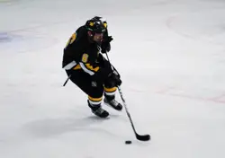 Gustavus Adolphus senior captain Cody Mosbeck brings the puck up ice late in the third period. Photo by Scott Bridges.