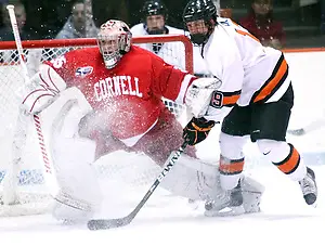 Photo By: Shelley M. Szwast Jack Berger (Princeton - 9) collides with goaltender Mike Garman (Cornell - 35) as Garman shifts to make a save on a shot from the point. (Shelley M. Szwast)