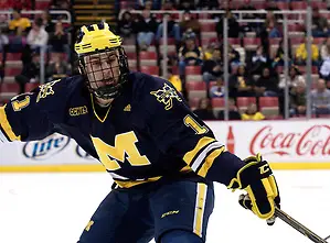 Michigan forward Kevin Lynch picks at the puck in Michigan Tech's zone. (Erica Treais)