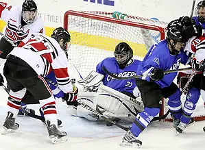 Alabama-Huntsville goalie Clarke Saunders traps the puck under his pads as UNO's Matt Ambroz (No. 27) and Rich Purslow (No. 9) close in. Saunders finished with 58 saves. Alabama-Huntsville beat UNO 2-1 in overtime Saturday night at Qwest Center Omaha. (Photo by Michelle Bishop) (Michelle Bishop)