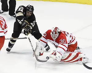Western Michigan Left Winger Derek Roehl tries to deflect a puck past a diving Miami goalie Cody Reichard during the first period of the CCHA Championship game at Joe Louis Arena on Saturday, March 19, 2011. (Rena Laverty)