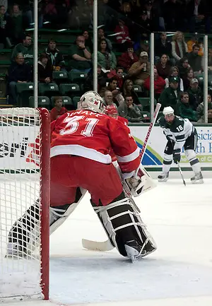 Miami goalie Connor Knapp anticipates the puck drop in his zone. Knapp recorded a shutout; the Redhawks defeated Michigan State 4-0. (Erica Treais)