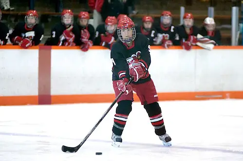 Photo By: 2012 Omar Phillips Allison Era of Plattsburgh controls the puck on the power play as her teammates look on from the bench (2012 Omar Phillips)
