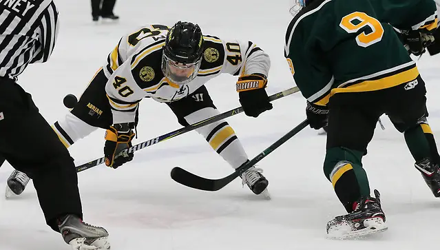 Bryan Yim of Adrian wins a faceoff against St. Norbert (Mike Dickie c/o Adrian Athletics)