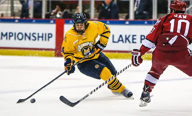 March 19, 2016:  Quinnipiac Bobcats defenseman Connor Clifton (4) skates with the puck as Harvard Crimson forward Brayden Jaw (10) tries to defend during 2016 ECAC Tournament Championship game between Harvard University and Quinnipiac University at Herb Brooks Arena in Lake Placid, NY. (John Crouch/J. Alexander Imaging)